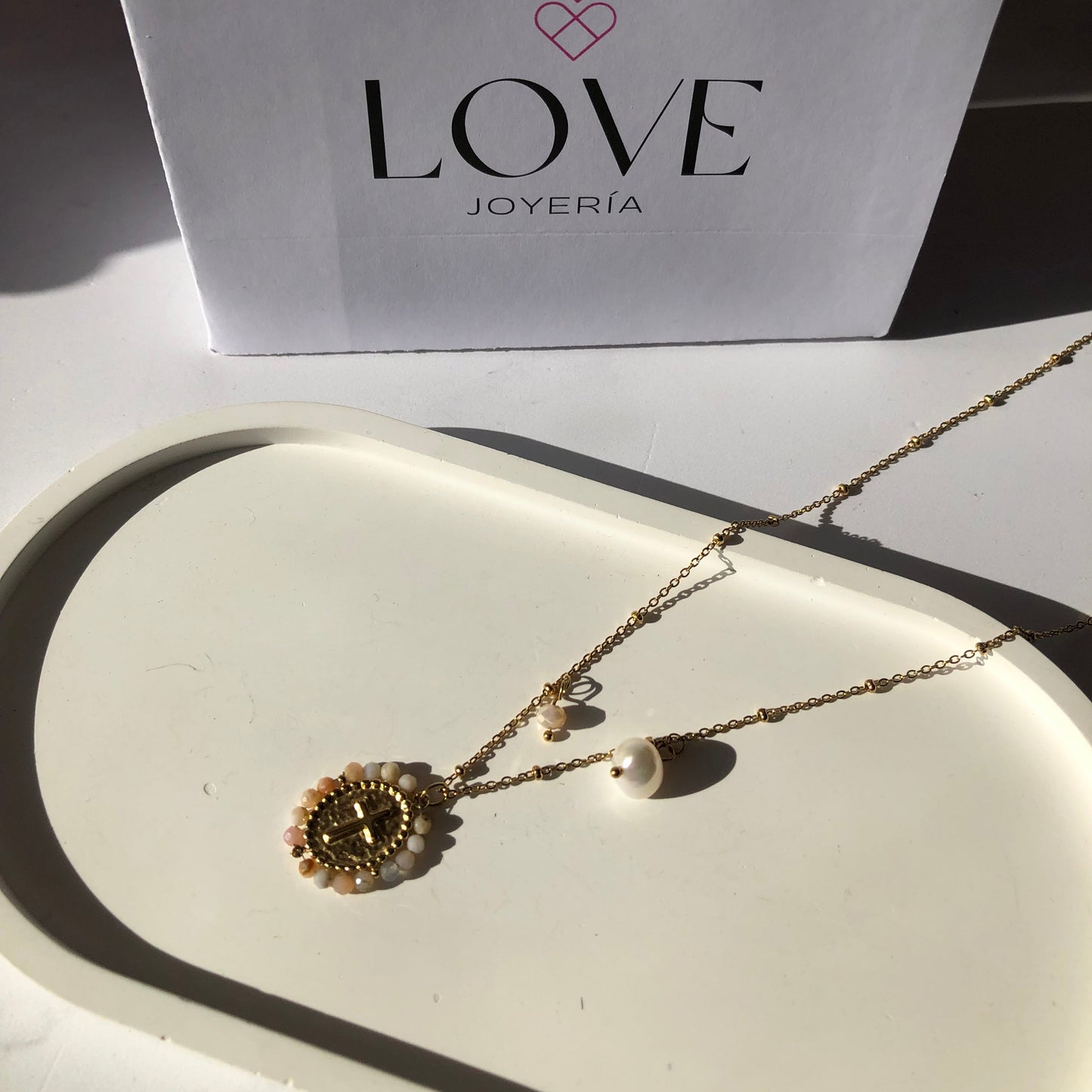 Collar cruz con piedras bordadas y perlita blanca